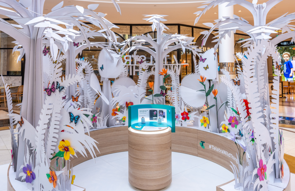 Timber circular base with paper like cut out trees and flowers for Telstra In The Wild Brand Activation at Highpoint Shopping Centre Roadshow